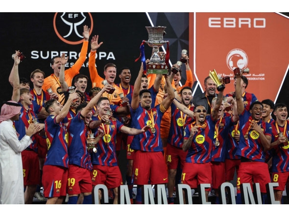 Barcelona's players raise the trophy as they celebrate after winning the Spanish Super Cup final football match between FC Barcelona and Real Madrid at the King Abdullah Stadium in Jeddah on January 11, 2026. (Photo by Fadel SENNA / AFP)