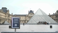 A photo shows an information panel notifying of the closure of the Louvre Museum on the empty plaza with the Louvre Pyramid, designed by Chinese-US architect Ieoh Ming Pei, as the museum is closed due a strike in Paris on January 12, 2026. Photo by Martin LELIEVRE / AFP