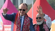 German Chancellor Friedrich Merz and Indian PM Narendra Modi wave to the crowd in Ahmedabad on January 12, 2026. (Photo by Shammi MEHRA / AFP)