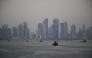 Tourists ride traditional boats along the corniche promenade in Doha on January 13, 2026. (Photo by Mahmud HAMS / AFP)
