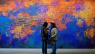 Visitors look at an artwork titled 