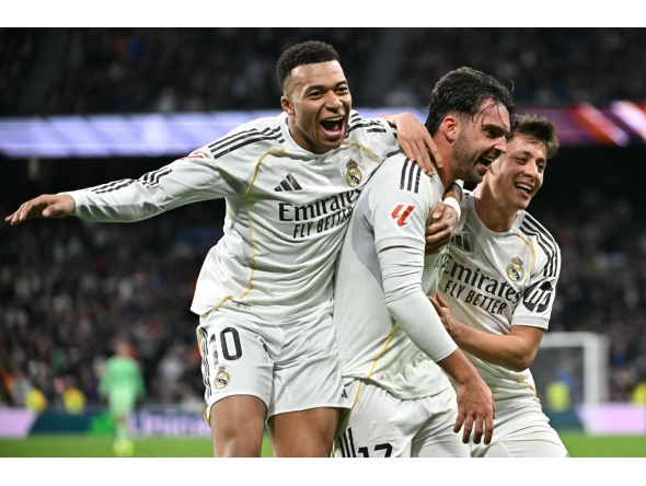 Real Madrid's Spanish defender #17 Raul Asencio (C) celebrates with Real Madrid's French forward #10 Kylian Mbappe (L) and Real Madrid's Turkish midfielder #15 Arda Guler after scoring his team's second goal during the Spanish league football match between Real Madrid CF and Levante UD at Santiago Bernabeu Stadium in Madrid on January 17, 2026. (Photo by Javier SORIANO / AFP)