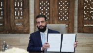 Syria's President Ahmed al-Sharaa signs an agreement at the Presidential Palace in Damascus on January 18, 2026. (Photo by Rami al SAYED / AFP)
