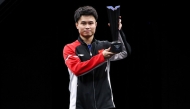 Zhou Qihao celebrates with the trophy.