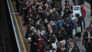 Commuters wait for a train on the platform at Earls Court Tube station in London on January 15, 2026. Photo by JUSTIN TALLIS / AFP