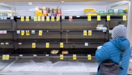 A person shops for eggs on mostly empty shelves as residents stock up ahead of a cold front expected in the area in Arlington, Virginia, on January 23, 2026. (Photo by Saul Loeb / AFP)