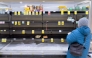 A person shops for eggs on mostly empty shelves as residents stock up ahead of a cold front expected in the area in Arlington, Virginia, on January 23, 2026. (Photo by Saul Loeb / AFP)