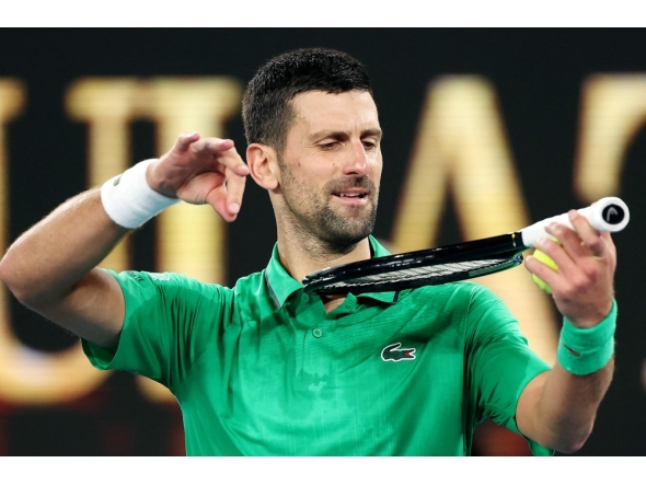 Serbia’s Novak Djokovic mimics playing a violin on his racket as he celebrates victory over Netherlands’ Botic van de Zandschulp on January 24, 2026. (Photo by Martin Keep / AFP)
