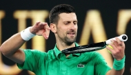 Serbia’s Novak Djokovic mimics playing a violin on his racket as he celebrates victory over Netherlands’ Botic van de Zandschulp on January 24, 2026. (Photo by Martin Keep / AFP)