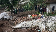 Rescuers search for victims buried by a landslide in Pasirlangu village, Bandung, West Java, on January 24, 2026, after Indonesia National Search and Rescue Agency (BASARNAS) said eight people were killed and 82 remain missing when the landslide struck early Saturday. (Photo by Timur Matahari / AFP)