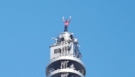 US rock climber Alex Honnold raises his arms from the top of the Taipei 101 building after he successfully free soloed the landmark skyscraper without ropes or safety gear in Taipei on January 25, 2026. (Photo by I-HWA CHENG / AFP)