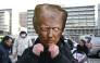 A protester wears a mask of US President Donald Trump during a rally condemning Trump's plans to raise tariffs in front of the US embassy in Seoul on January 27, 2026. (Photo by Jung Yeon-je / AFP)