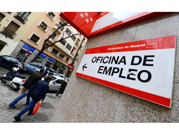 People walk outside a government employment office in the center of Madrid on January 3, 2014. Photo by GERARD JULIEN / AFP