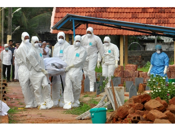 Representational file photo. Doctors and relatives wearing protective gear dig a grave to bury a victim of the brain-damaging Nipah virus in Kozhikode, Kerala, India, May 24, 2018. Reuters/Stringer