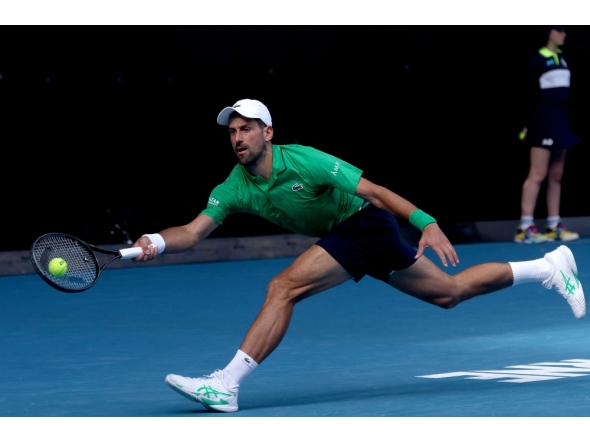 Serbia's Novak Djokovic hits a return to Italy's Lorenzo Musetti during their men's singles quarter-final match on day eleven of the Australian Open tennis tournament in Melbourne on January 28, 2026. (Photo by Izhar Khan / AFP) 