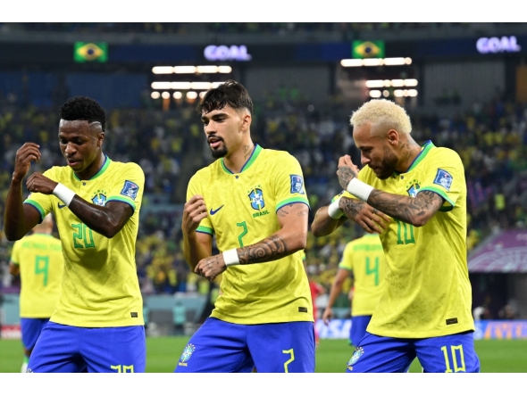 (FILES) Brazil's forward #20 Vinicius Junior celebrates scoring his team's first goal with Brazil's midfielder #07 Lucas Paqueta (C )and Brazil's forward #10 Neymar during the Qatar 2022 World Cup round of 16 football match between Brazil and South Korea at Stadium 974 in Doha on December 5, 2022. (Photo by MANAN VATSYAYANA / AFP)