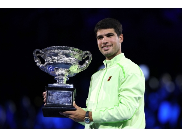Spain's Carlos Alcaraz poses with the Norman Brookes Challenge Cup after defeating Serbia's Novak Djokovic in Melbourne on February 1, 2026. (Photo by Martin Keep / AFP)