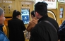 Customers wait to sell their gold jewelry in a Smart Gold Store Machine placed in a shopping mall in Shanghai on January 29, 2026. (Photo by Hector RETAMAL / AFP) 