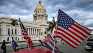 Two US flags and a Cuban flag flutter on the roof of a tricycle in front of the Capitolio in Havana on February 3, 2026. (Photo by YAMIL LAGE / AFP)
