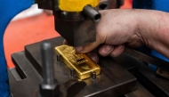 A gold bar weighing 1000 grams is minted at the Austrian Gold and Silver Refinery (Oegussa) in Vienna, Austria, on February 3, 2026. (Photo by Georg Hochmuth / APA / AFP) 