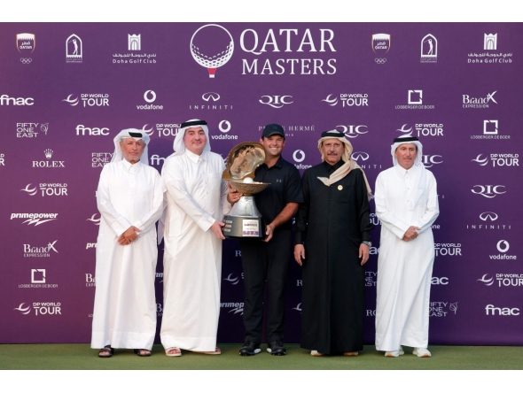 US' Patrick Reed celebrates on the podium with the trophy after winning the Qatar Masters 2026 golf tournament at Doha Golf Club in Doha on February 8, 2026. (Photo by Karim JAAFAR / AFP)
