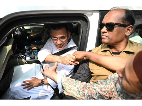 Bangladesh Nationalist Party (BNP) chairman and election candidate Tarique Rahman (L) greets his supporters in Dhaka on February 13, 2026. (Photo by Munir Uz Zaman / AFP)