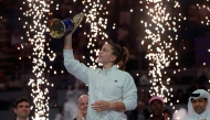 Czech Republic's Karolina Muchova reacts as she holds up the winner's trophy after beating Canada's Victoria Mboko in the women singles final match, at the Qatar Open tennis tournament in Doha on February 14, 2026. (Photo by Karim JAAFAR / AFP)