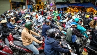 Motorists cross railway tracks on the motorbikes after a train passed on the popular train street in Hanoi on February 13, 2026. (Photo by Amaury Paul / AFP)
