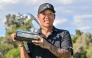 4Aces GC player Anthony Kim from the US celebrates with the trophy after winning the LIV Golf Adelaide tournament at The Grange Golf Club in Adelaide on February 15, 2026. (Photo by Brenton Edwards / AFP)