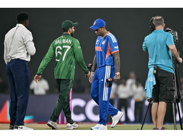 India's captain Suryakumar Yadav (2R) walks past his Pakistan counterpart Salman Agha (2L) after the toss before the start of the 2026 ICC Men's T20 Cricket World Cup group stage match between India and Pakistan at the R Premadasa Stadium in Colombo on February 15, 2026. (Photo by Manan VATSYAYANA / AFP)