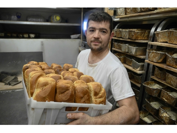 French volunteer baker Loic Nervi holds a basket of freshly baked bread in his mobile bakery in Borodyanka, Kyiv region on February 19, 2026. (Photo by Genya Savilov / AFP)