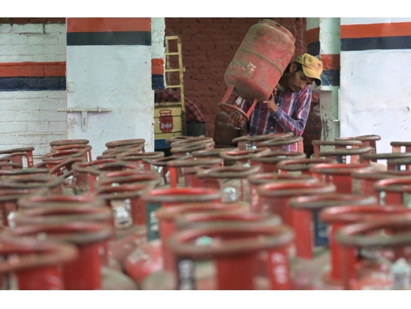 A  delivery staff carries liquefied petroleum gas (LPG) cylinders at a distribution centre in Amritsar on March 10, 2026. (Photo by Narinder Nanu / AFP)