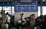 A man takes pictures of a board with a sign for the K27 train bound for Pyongyang as passengers wait for their train at Beijing Railway Station in Beijing on March 12, 2026. The first passenger train service from North Korea to China crossed the border March 12 for the first time in six years, Yonhap News Agency reported. (Photo by Adel Berry/ AFP)
 