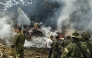 This screen grab shows soldiers and rescuers near an Air Force Hercules emitting thick smoke after the aircraft crashed during takeoff in Puerto Leguizamo, Colombia, near the southern border with Ecuador, on March 23, 2026. (Photo by daniel ortiz / AFP)
