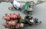 A delivery man transports liquid petroleum gas (LPG) cylinders in Amritsar on March 24, 2026. Photo by Narinder Nanu / AFP

