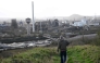 A tourist walks down a slag heap next to abandoned steel plants in Charleroi, southern Belgium, on March 11, 2026. (Photo by Nicolas Tucat / AFP)