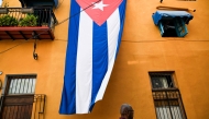 A man walks past a Cuban flag hanged on the facade of a house in Havana on March 26, 2026. (Photo by Yamil Lage / AFP)