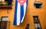 A man walks past a Cuban flag hanged on the facade of a house in Havana on March 26, 2026. (Photo by Yamil Lage / AFP)