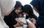 15-year-old girls use their smartphones on a street in Jakarta on March 26, 2026. (Photo by Yasuyoshi Chiba / AFP) 
