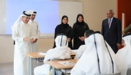 Undersecretary of the Ministry of Education and Higher Education H E Dr. Ibrahim bin Saleh Al-Nuaimi interacts with students in a classroom during his visit to a school.