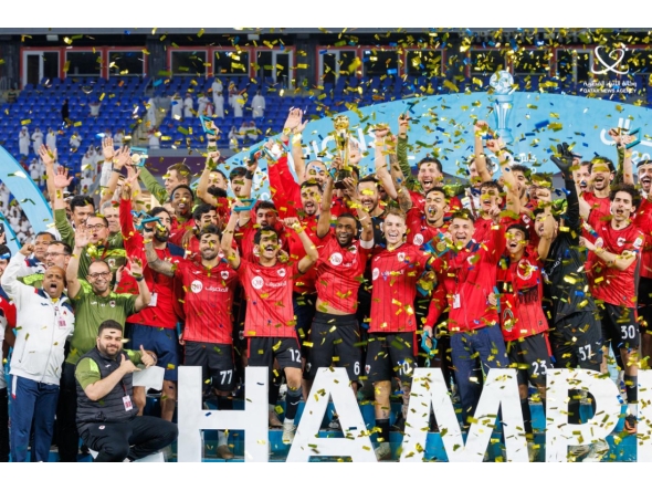 Al Rayyan players and officials celebrate with the trophy.