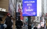 Tourists walk past a “Welcome BTS” sign in Myeong-dong, central Seoul, on Friday, a day ahead of the group’s comeback concert. (Lee Sang-sub/The Korea Herald)