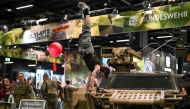 A visitor performs on a reconnaissance vehicle of the German Federal army Bundeswehr at their booth at the FIBO trade show for health, fitness and wellness in Cologne, western Germany on April 16, 2026. (Photo by Ina Fassbender / AFP)