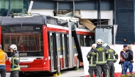 Firefighters and rescue personnel stand next to a trolleybus that crashed into a supermarket on April 20, 2026 in Salzburg, Austria. (Photo by various sources / AFP) 