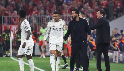 Real Madrid's Spanish coach Alvaro Arbeloa (2nd R) and Real Madrid's French forward #10 Kylian Mbappe (2nd L) are seen on the sidelines during the UEFA Champions League quarter-final second leg football match between FC Bayern Munich and Real Madrid in Munich, southern Germany, on April 15, 2026. (Photo by Karl-Josef HILDENBRAND / AFP)