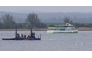 The MS Adler nature tourist boat (R, background) navigates past a stranded humpback whale (R) off the Baltic Sea coast at the island of Poel, near the small village of Weitendorf-Hof, northern Germany, on April 19, 2026, as a rescue team on a boat with equipment is seen close to the animal. Photo by Danny GOHLKE / AFP