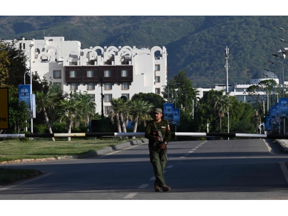 A policer officer stands guard near the Serena Hotel at the Red Zone area in Islamabad on April 22, 2026. (Photo by Aamir Qureshi / AFP)