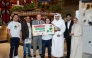 Head of Operations Balu Subramanion, COO Vyanktesh Jaiswal, Tawar Mall MD Yacoub Boutros, and MD Sajed Jassim Mohammed Sulaiman, joined by his family, present the award to the winner.