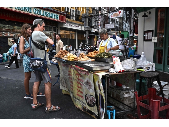 THAILAND-BANGKOK-FOOD-CULTURE-ECONOMY
Content :This photo taken on April 29, 2026 shows street food vendor Thitisakulthip Sang-uamsap selling fried vegetarian snacks to visitors in Chinatown in Bangkok. 
(Photo by Lillian SUWANRUMPHA / AFP) 
 