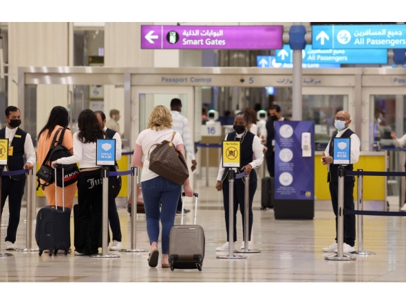 (FILES) A picture shows passengers walking towards the gates at terminal 3 at Dubai international Airport, in the Gulf emirate of Dubai, on August 16, 2022.
(Photo by Giuseppe Cacace / AFP)